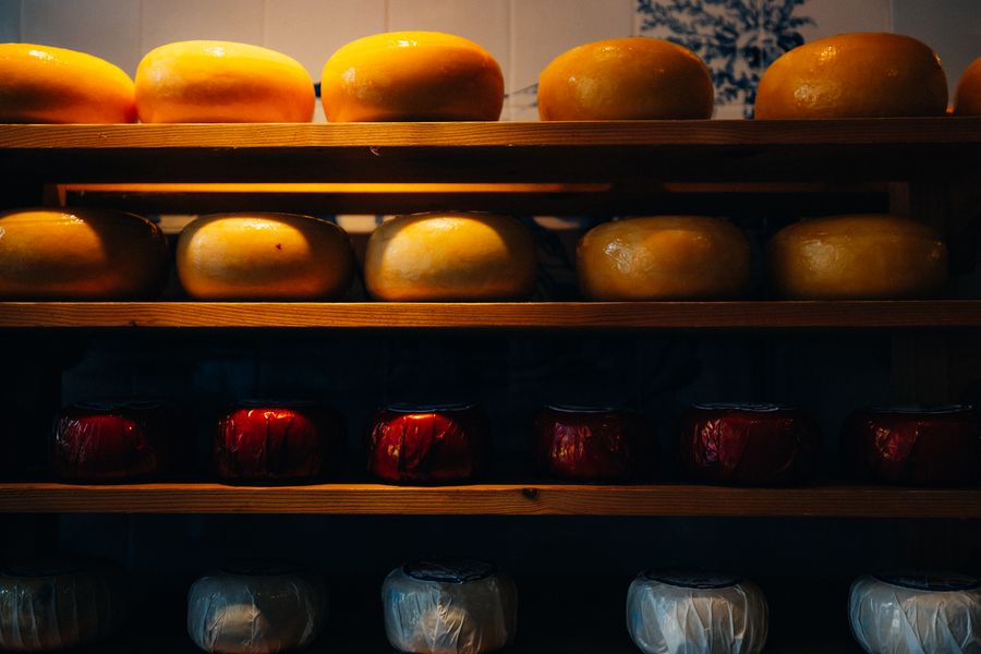 Meules de Gouda et d'Edam alignées sur des étagères
