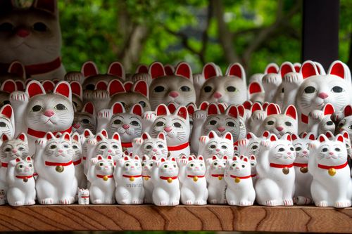Free A collection of lucky cat figurines, known as Maneki-neko, displayed outdoors. Stock Photo