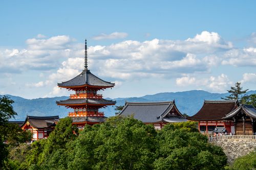 Free View of Kiyomizu-dera Temple's pagoda amidst lush greenery with mountains in Kyoto, Japan. Stock Photo