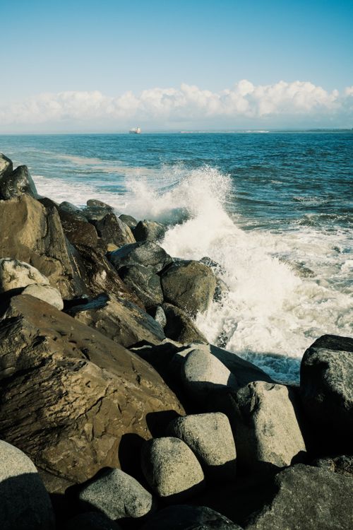 Free Dynamic ocean waves crash against a rocky shoreline, capturing the powerful essence of nature. Stock Photo