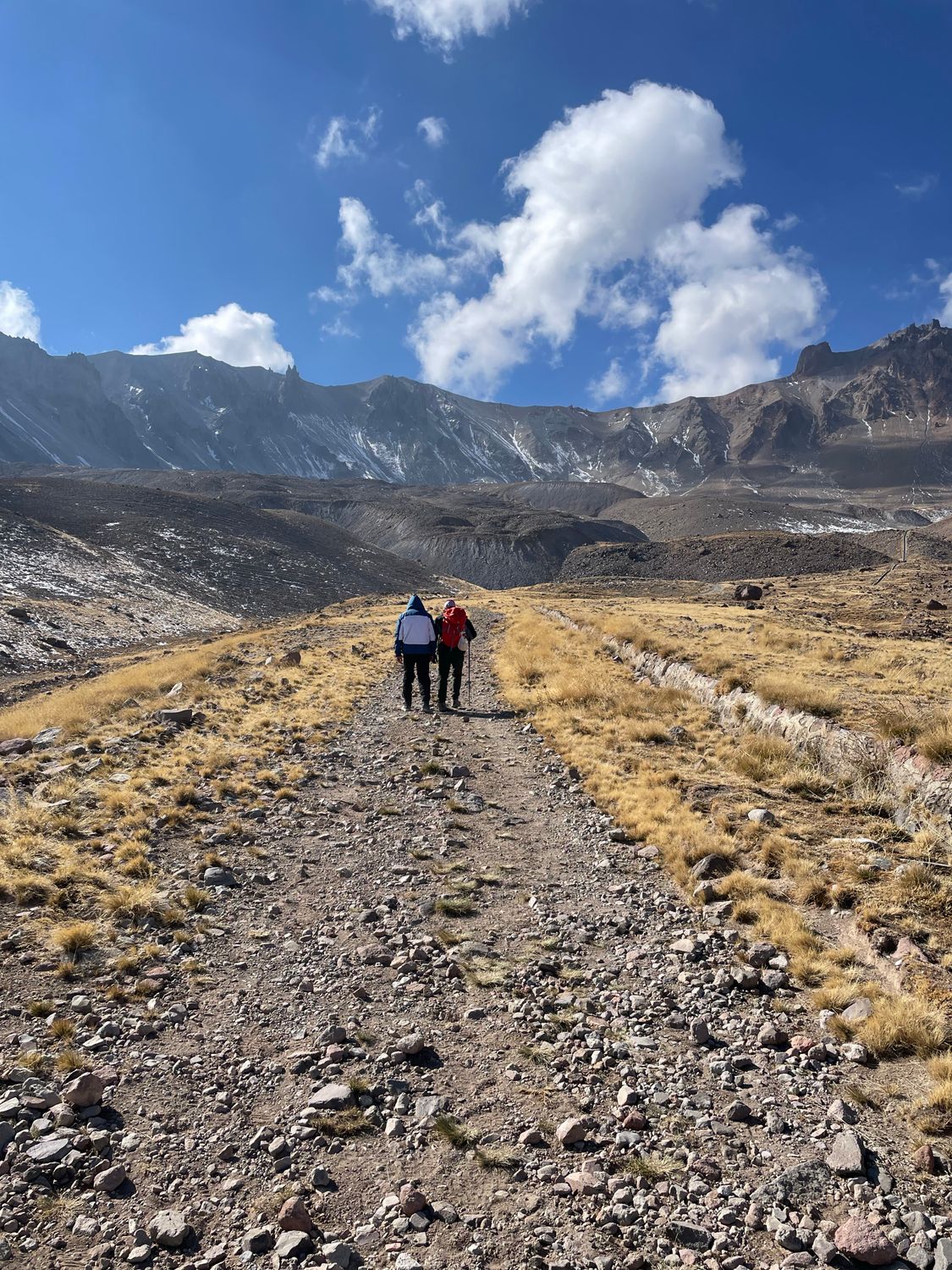 Hikers on Rugged Trail with Mountain Backdrop · Free Stock Photo