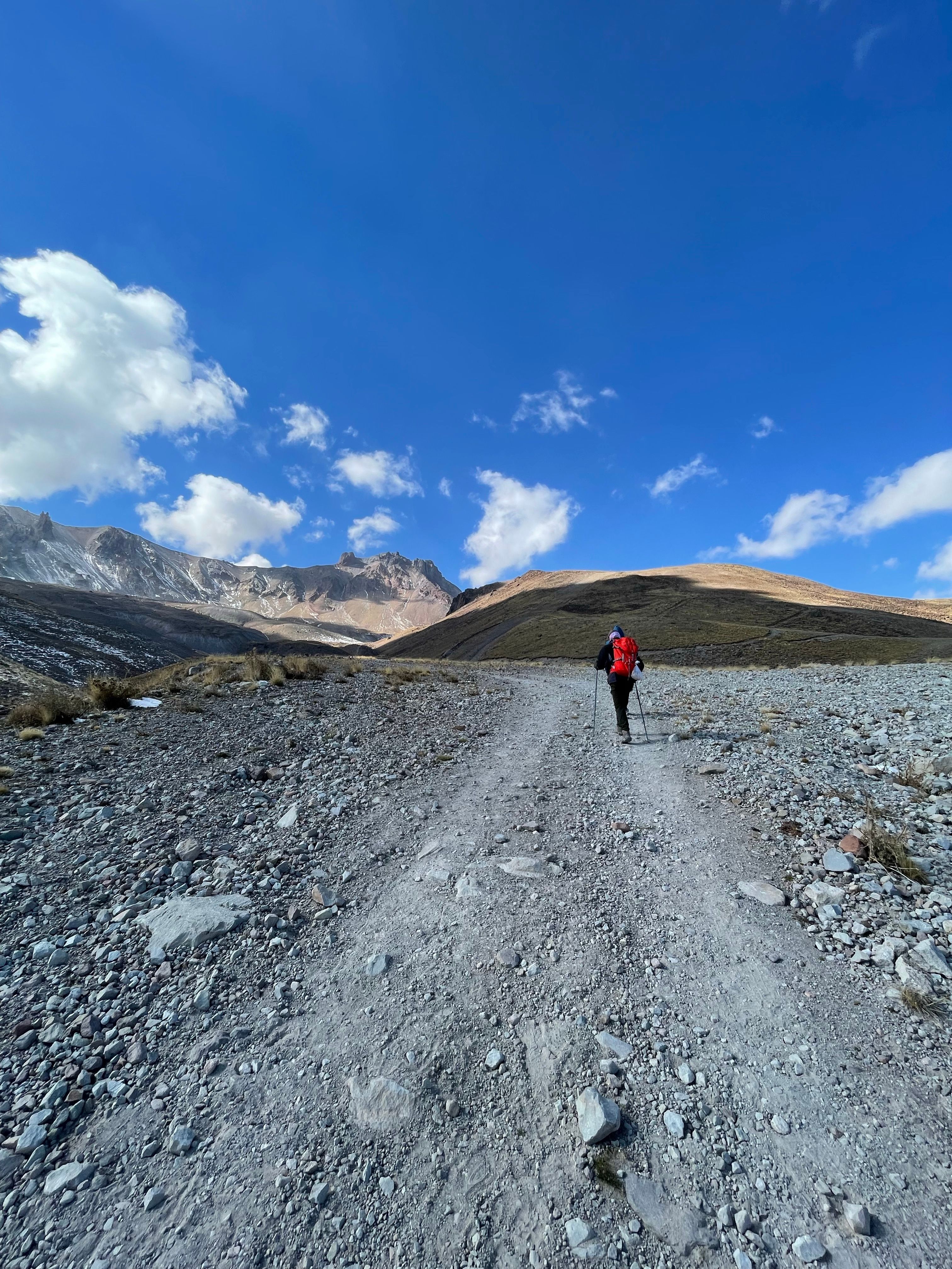 Walker on a high trail under clear sky — photo by Eren Sever on Pexels