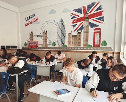 Students studying English in a classroom with British themed decor and mural.