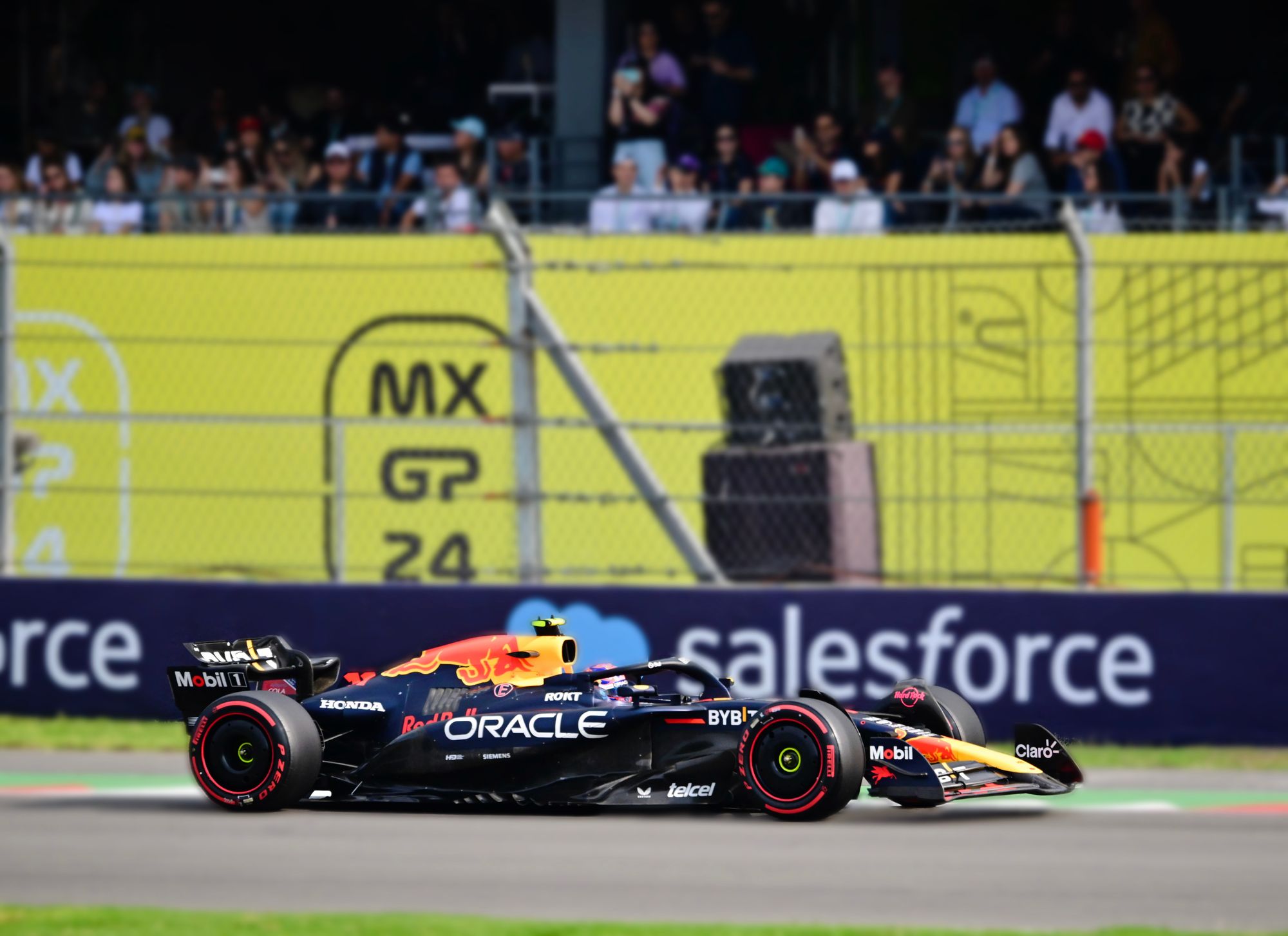 Dynamic shot of an F1 car racing at Mexico City Grand Prix with a cheering crowd in the background.