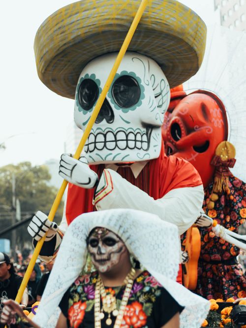 Free Vibrant parade with Day of the Dead costumes and large skull figures in Mexico City. Stock Photo