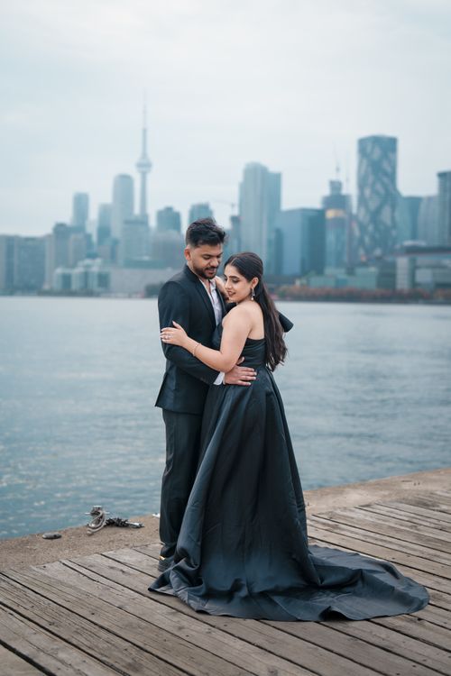 Free A couple embraces on a pier with the iconic Toronto skyline in the background. Stock Photo