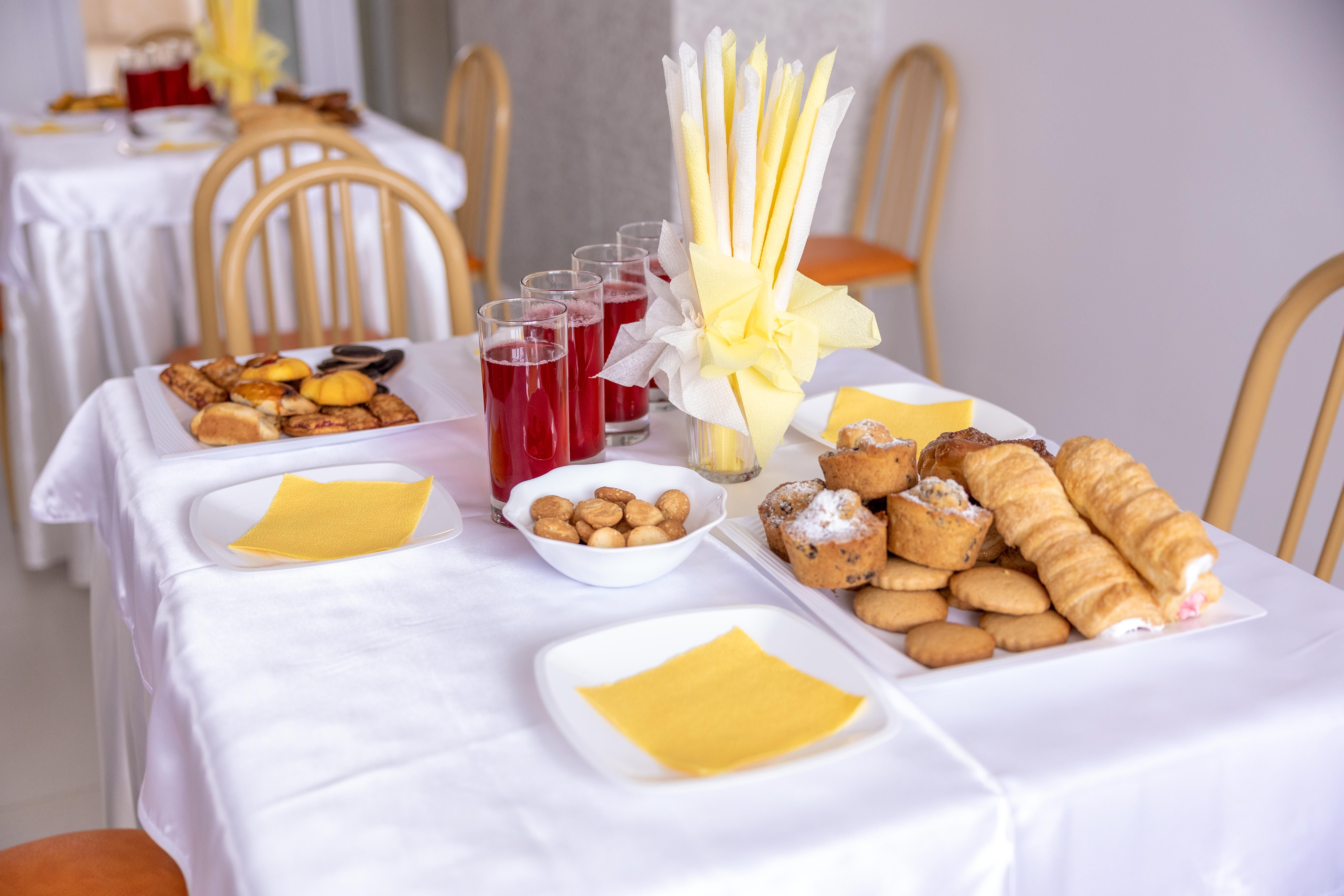 A beautifully arranged table with pastries, juice, and elegant napkin display, perfect for events.