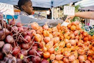 农贸市场上，出售新鲜甜菜的场景生动地突出了当地的农产品和社区商业