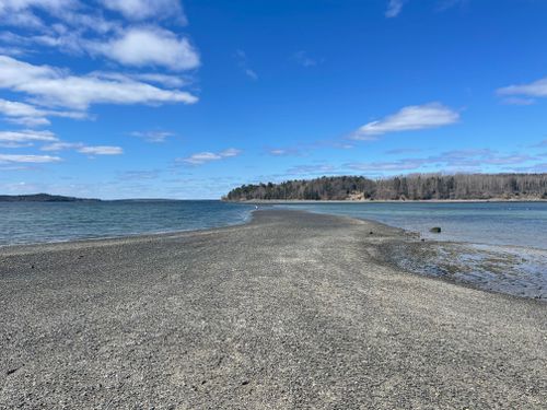 Free A beautiful sandbar leading to a forested island under a blue sky in Bar Harbor, Maine. Stock Photo