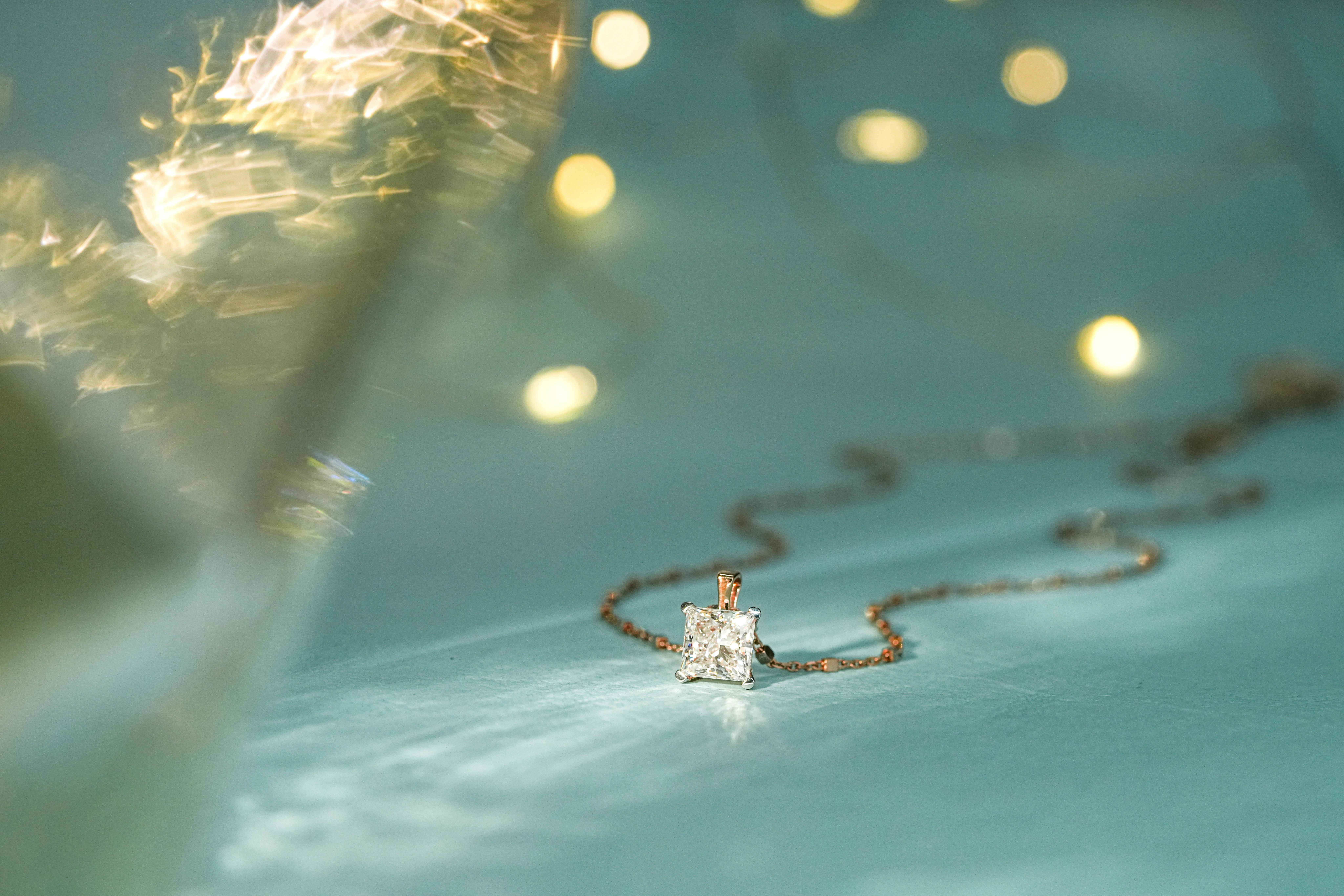 Close-up of a sparkling diamond pendant on a delicate chain, perfect for festive occasions.