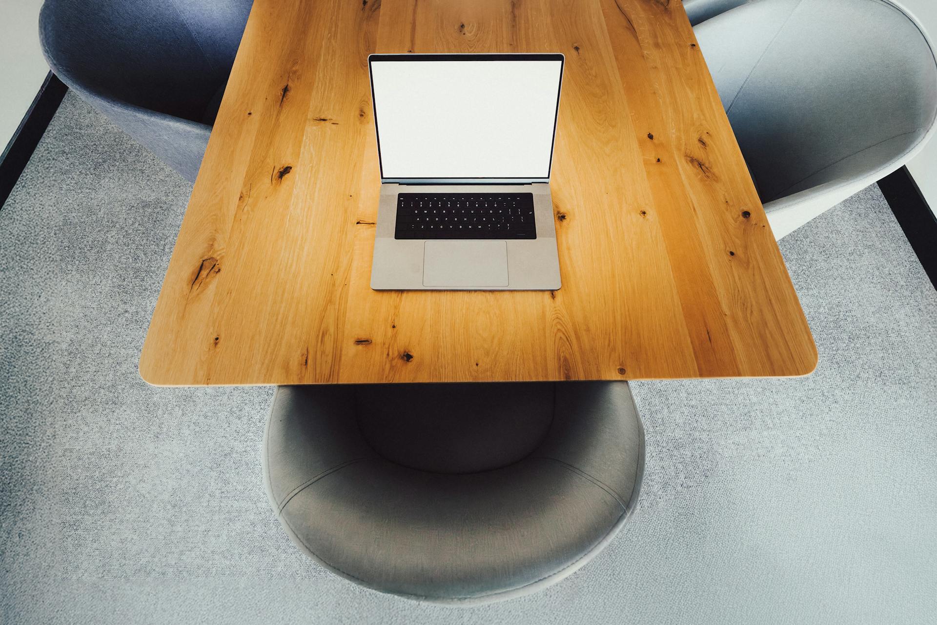 laptop empty white screen mockup business meeting room interior comfortable armchairs wooden table