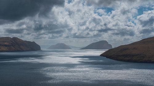 Free Dramatic seascape of the Faroe Islands with mossy cliffs and a cloudy sky. Stock Photo