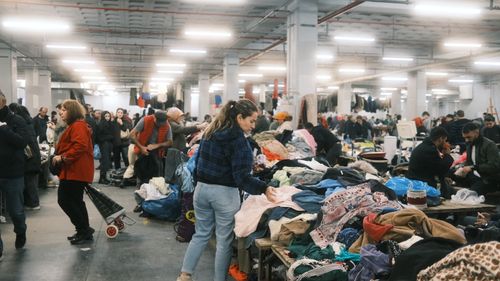 Free Crowded indoor flea market in Istanbul with people browsing textiles and clothes. Stock Photo