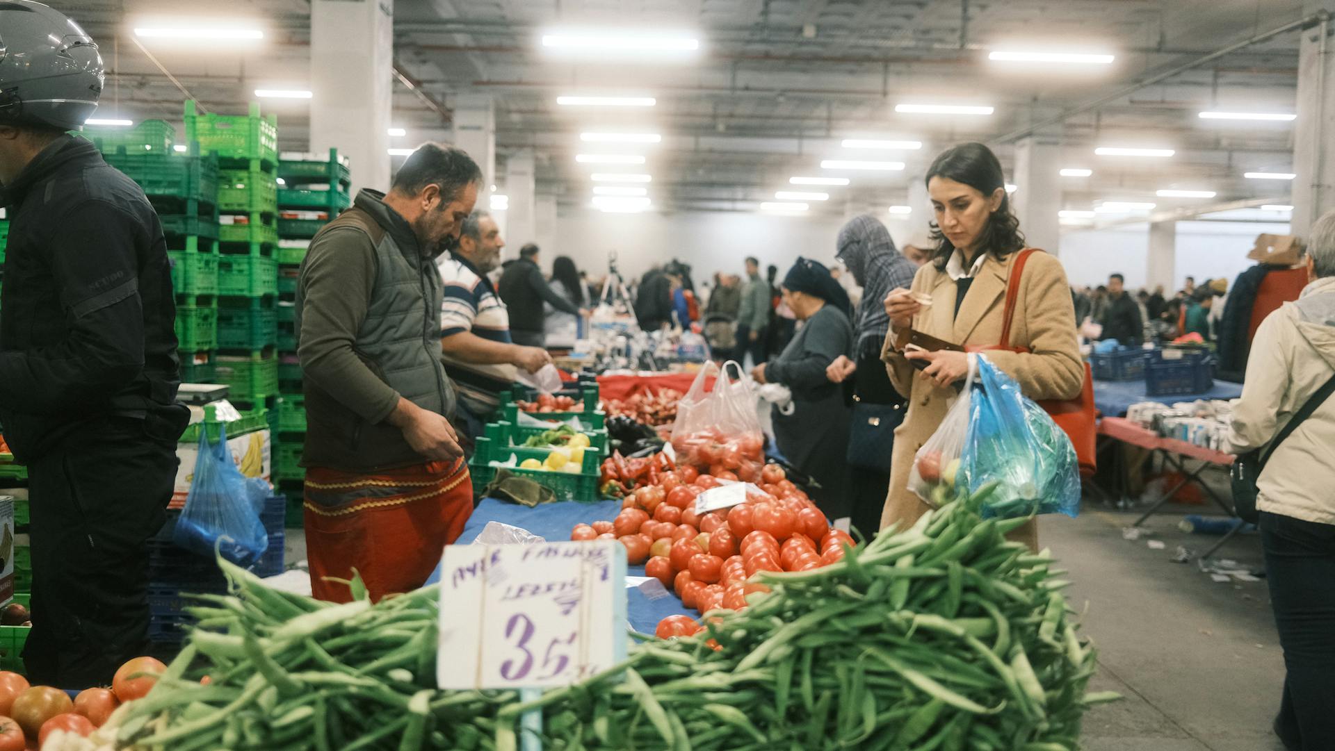 A lively scene of an indoor marketplace in İstanbul with vendors and shoppers.