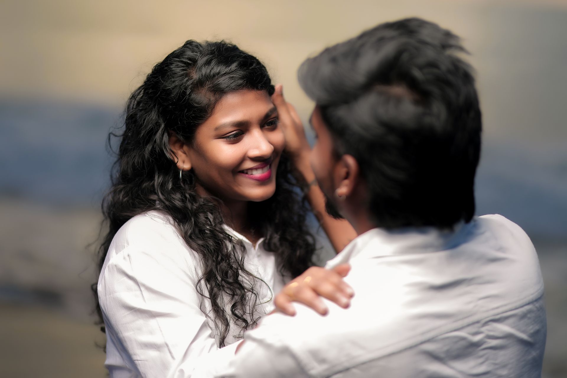 A joyful couple sharing an affectionate moment with smiles and warmth.