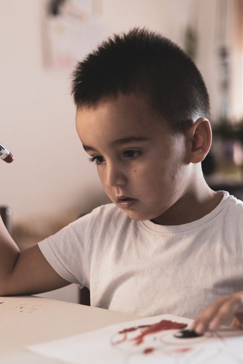 Free Child engaged in drawing indoors, showcasing concentration and creativity. Stock Photo