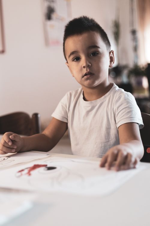 Free Young boy focused on art, drawing in a cozy indoor setting, fostering creativity. Stock Photo