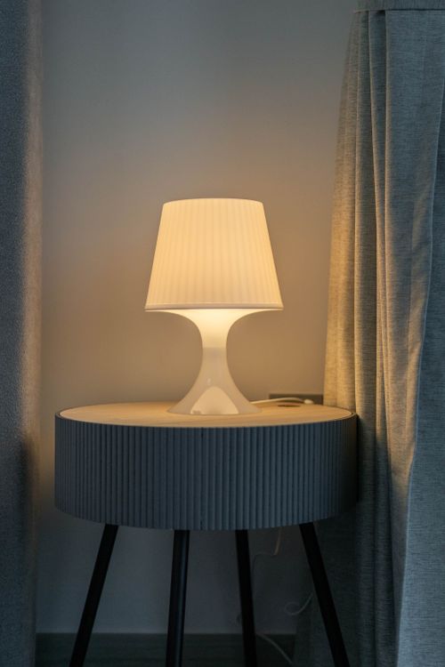 Free A stylish modern lamp on a round table creates a serene ambiance in a Dubai interior. Stock Photo