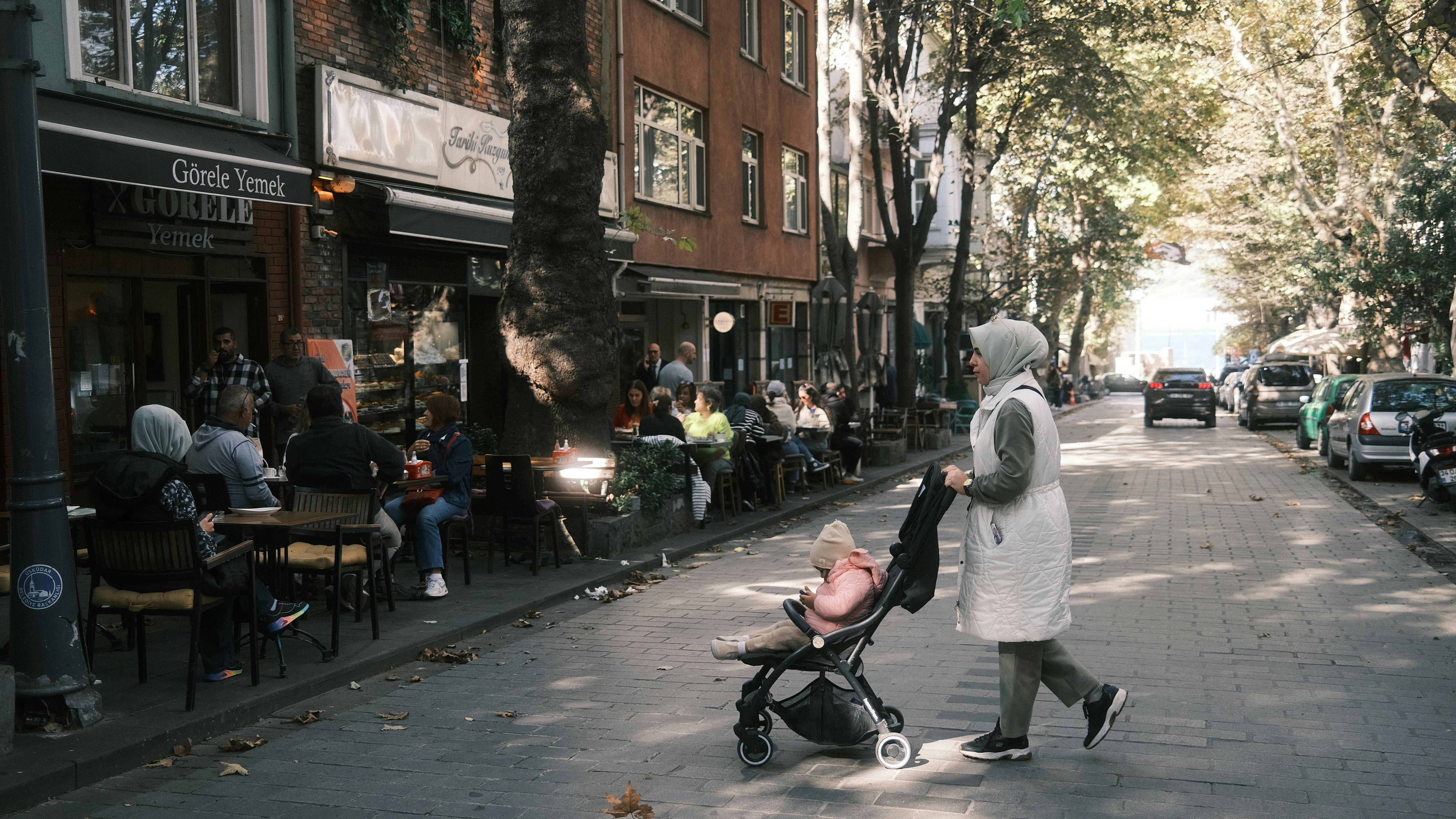 family walking near neighborhood cafe street scene soft afternoon light