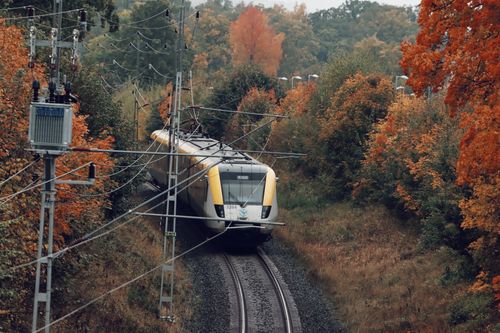 Free A yellow train travels through a vibrant autumn forest in rural Jönköping, Sweden. Stock Photo