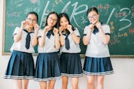 Four students posing playfully in classroom