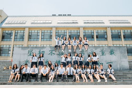 Free Large group of students in school uniforms posing outdoors on a sunny day. Stock Photo