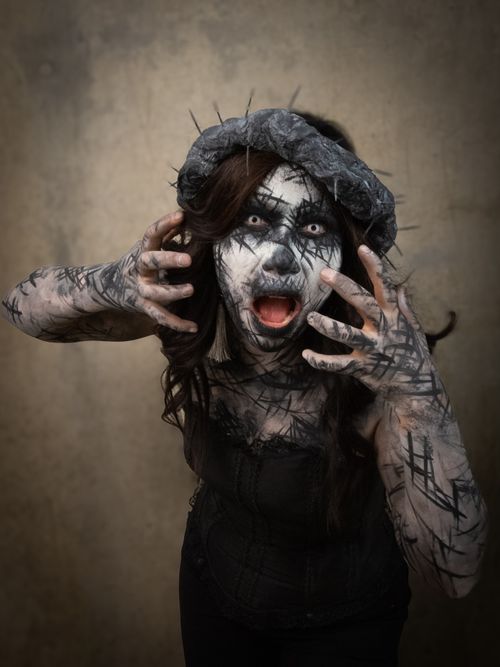 Free Spooky Halloween costume with eerie makeup and dramatic pose indoors. Stock Photo