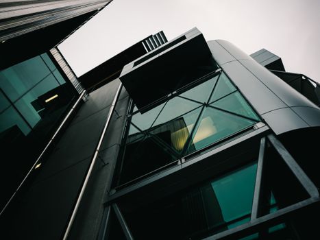 Low angle view of a modern building with geometric glass and metal design.
