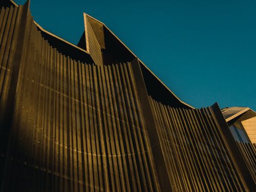 Free A dramatic view of a modern architectural facade with bold patterns under clear skies. Stock Photo