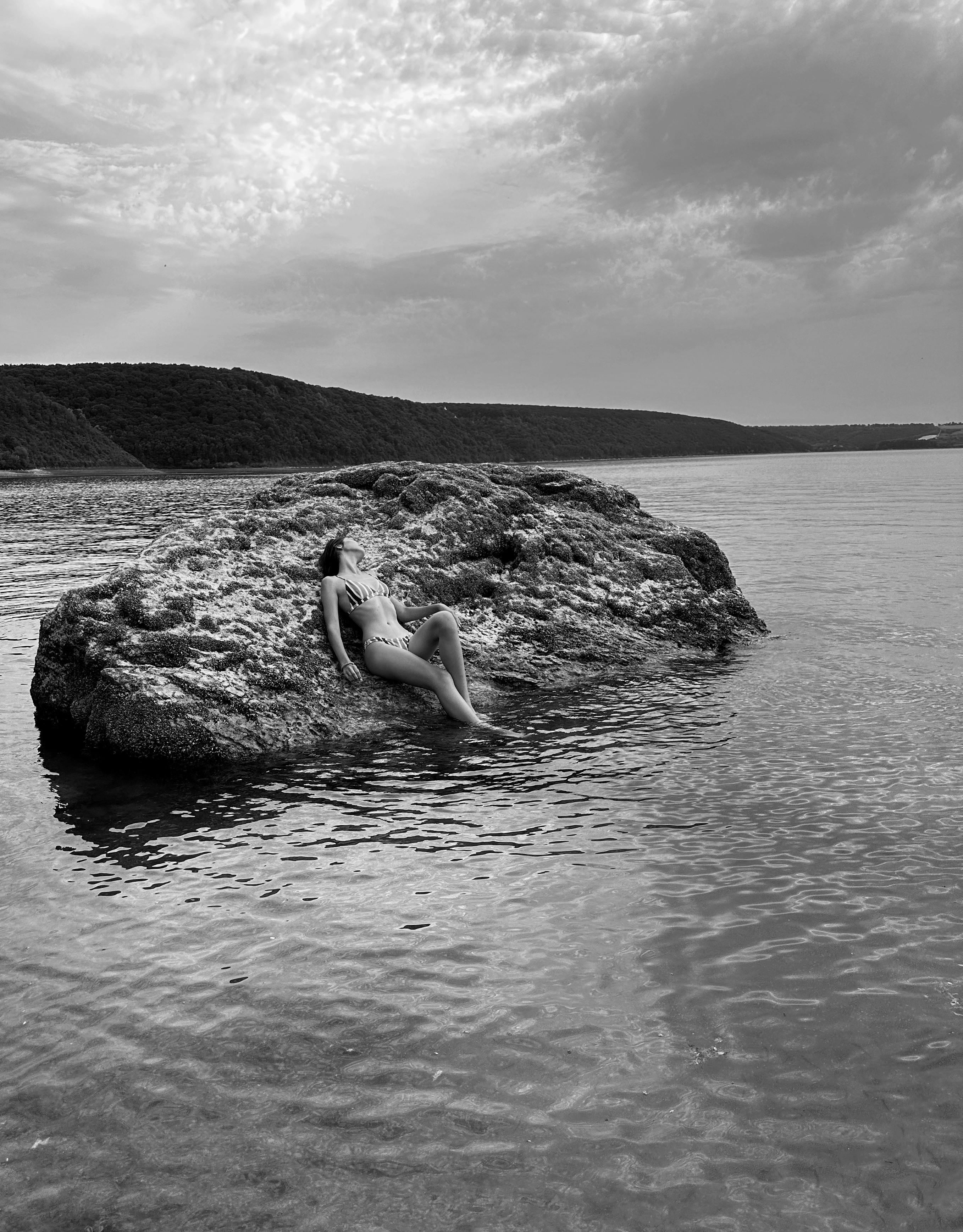 Woman Relaxing on Rock by Tranquil Lake · Free Stock Photo