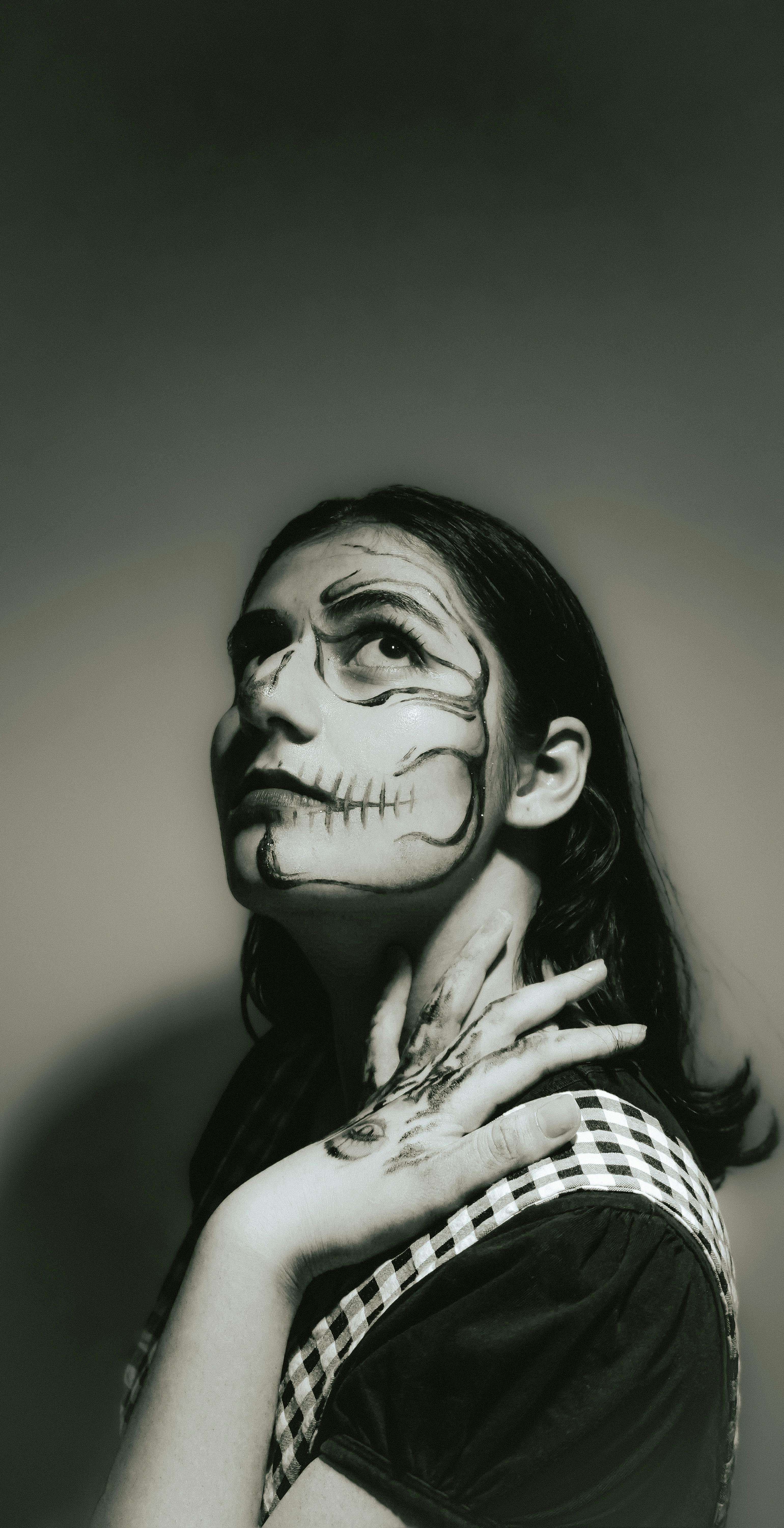 Artistic portrait with Halloween makeup in black and white, showcasing a skull-inspired face paint on an adult.
