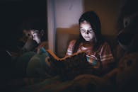 Young Girl Reading in a Cozy Dimly Lit Room