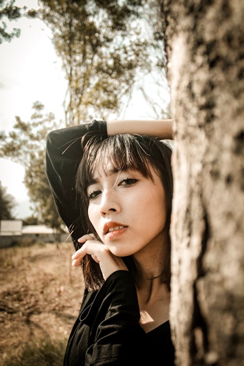 Woman in Black Top Near Tree Trunk