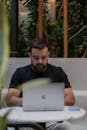 Man Working on Laptop in Modern Cafe