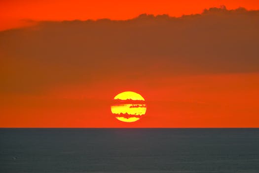 Gorgeous red sunset over the ocean with clouds aligning the horizon.