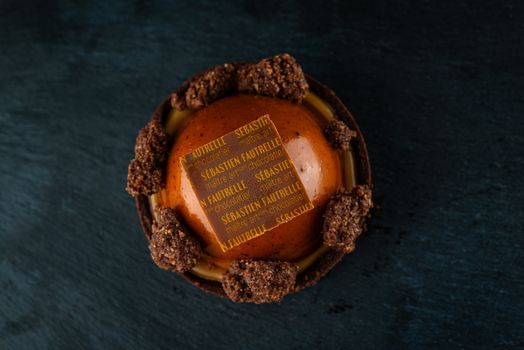 Delicious gourmet chocolate pastry showcasing intricate design on a dark background.