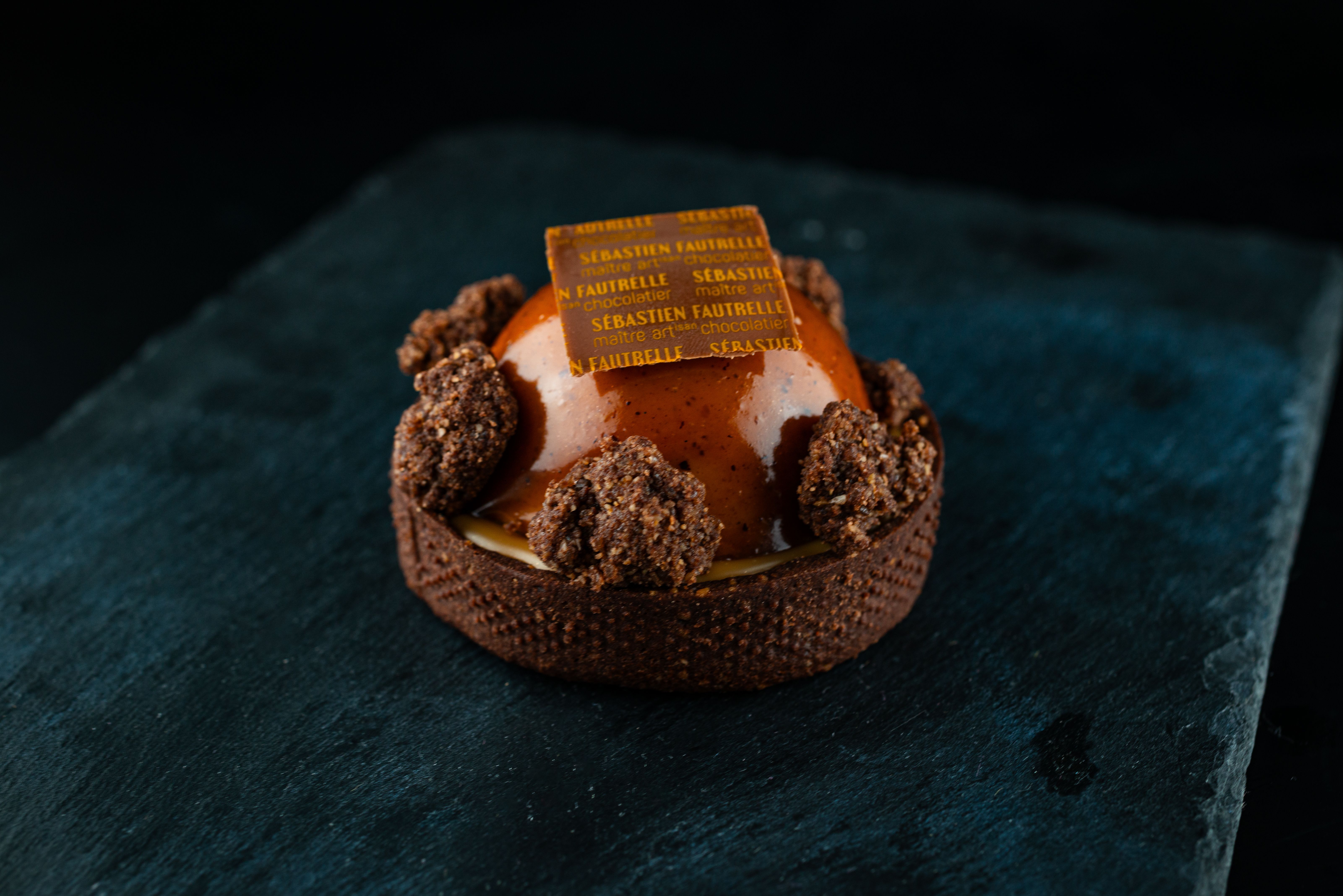 Laissez-vous tenter par une riche pâtisserie au chocolat, magistralement présentée sur une surface en ardoise, parfaite pour les gourmets.