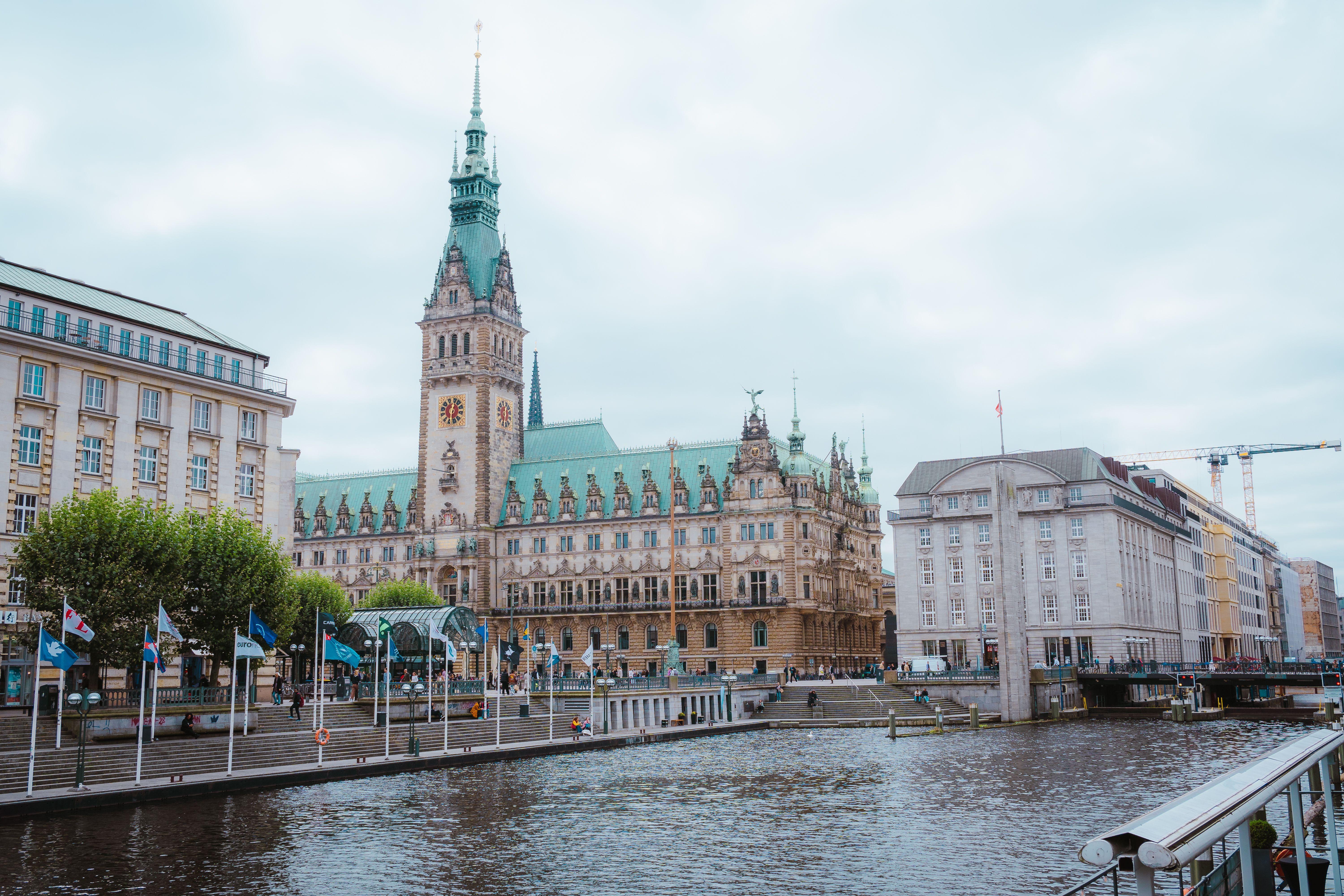 Scenic view of Hamburg Town Hall with canal, capturing classic European architecture in Germany.