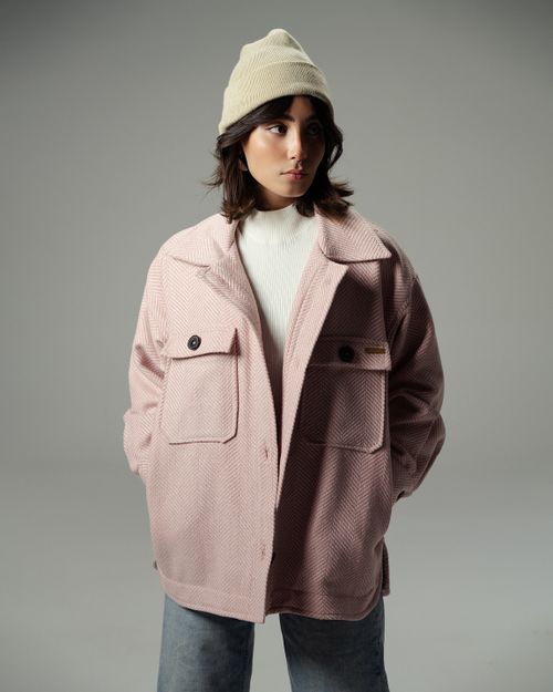 Free Fashionable woman in a pink jacket and beanie posing in a studio setting. Stock Photo