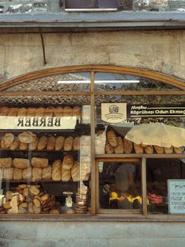 Window view of a traditional bakery showcasing a variety of fresh bread loaves.