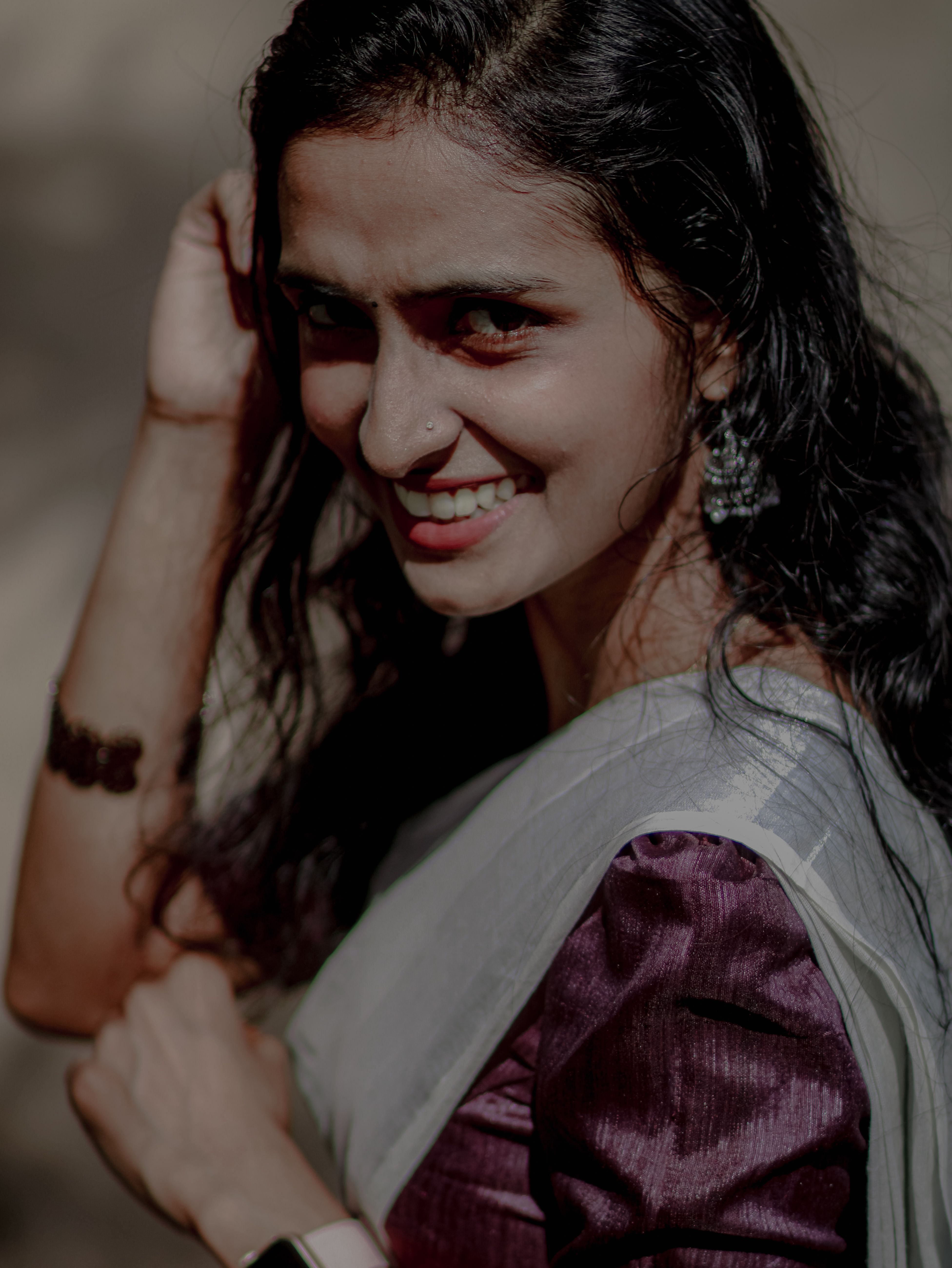 A woman in traditional Indian dress smiling outdoors in Ernakulam, Kerala.