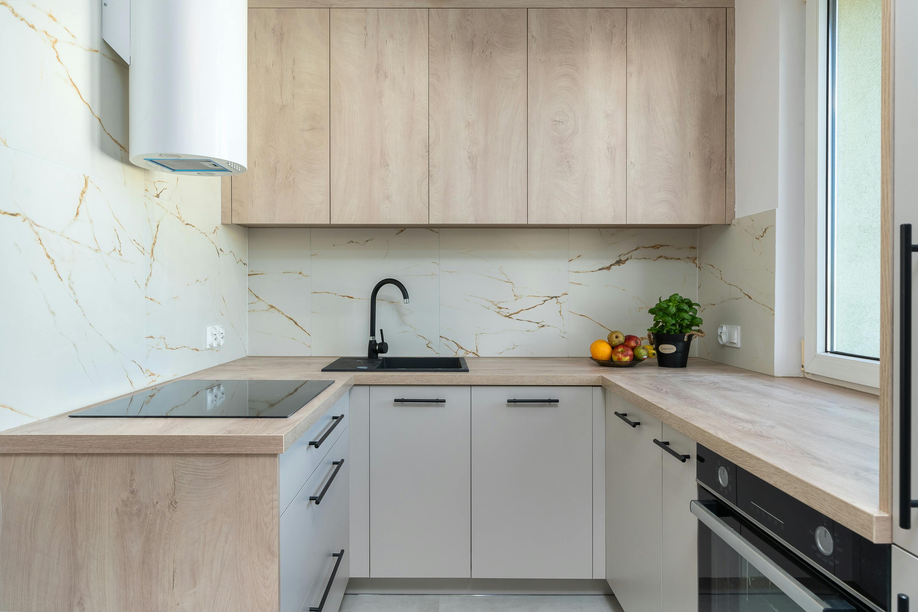 Cocina minimalista moderna con salpicadero de mármol y armarios oscuros