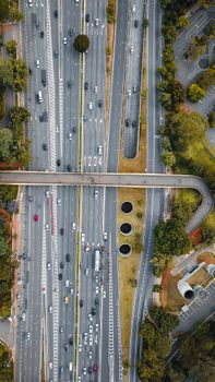 Aerial shot of a busy highway intersection surrounded by greenery.