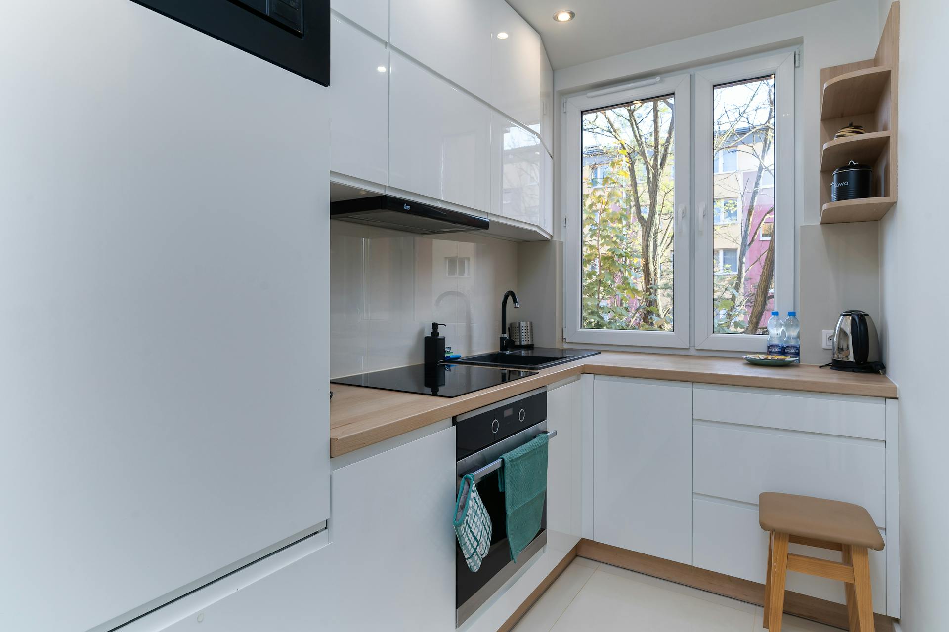 Bright and clean minimalist kitchen with white cabinetry and natural light.