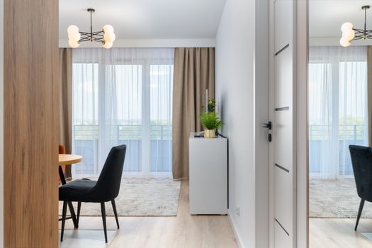 Elegant modern living room interior featuring minimalist decor with a stylish dining area and bright natural light.