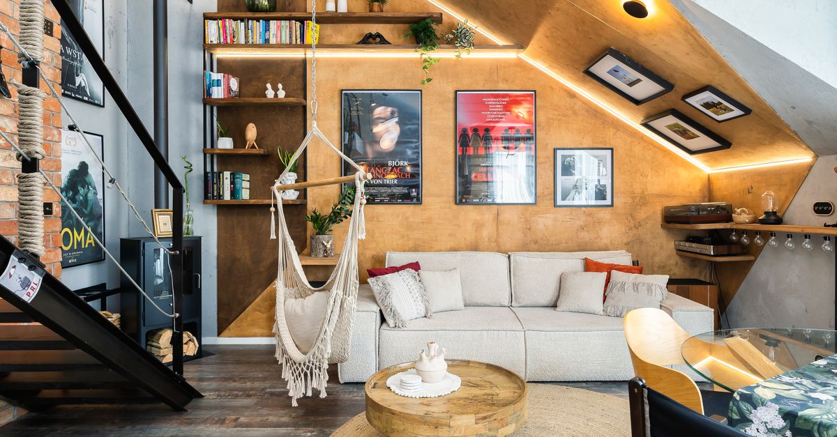 Stylish modern living room featuring rustic decor, hammock chair, and bookshelf for a cozy atmosphere.