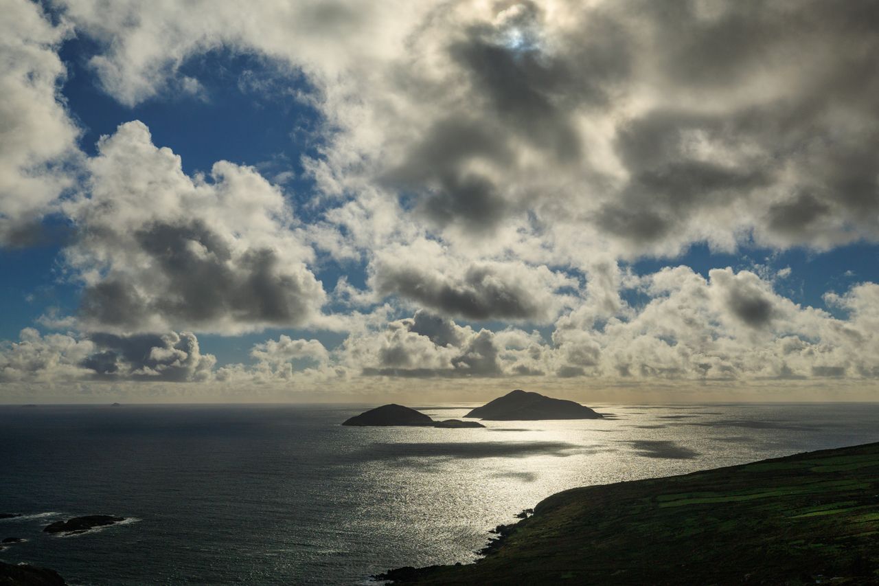 Rocky islands rising out of the Atlantic off the coast of County Kerry under a wide, dramatic sky