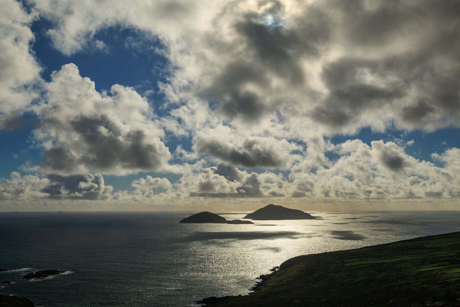 Clouds over Skellig Islands in Ireland with shimmering sea view