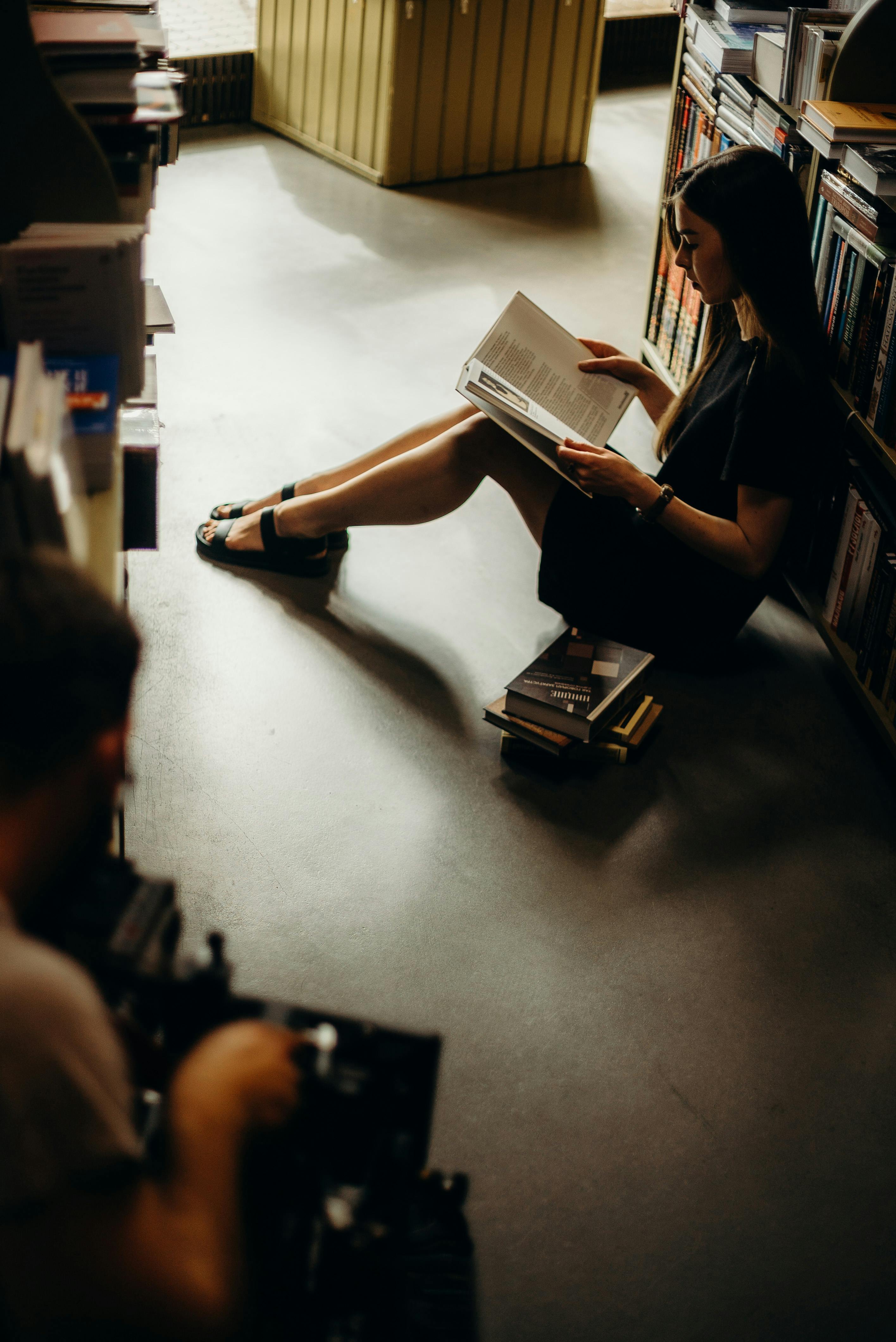 woman sitting on floor reading book