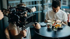 摄影师在舒适的咖啡馆里捕捉电影氛围，拍摄场景